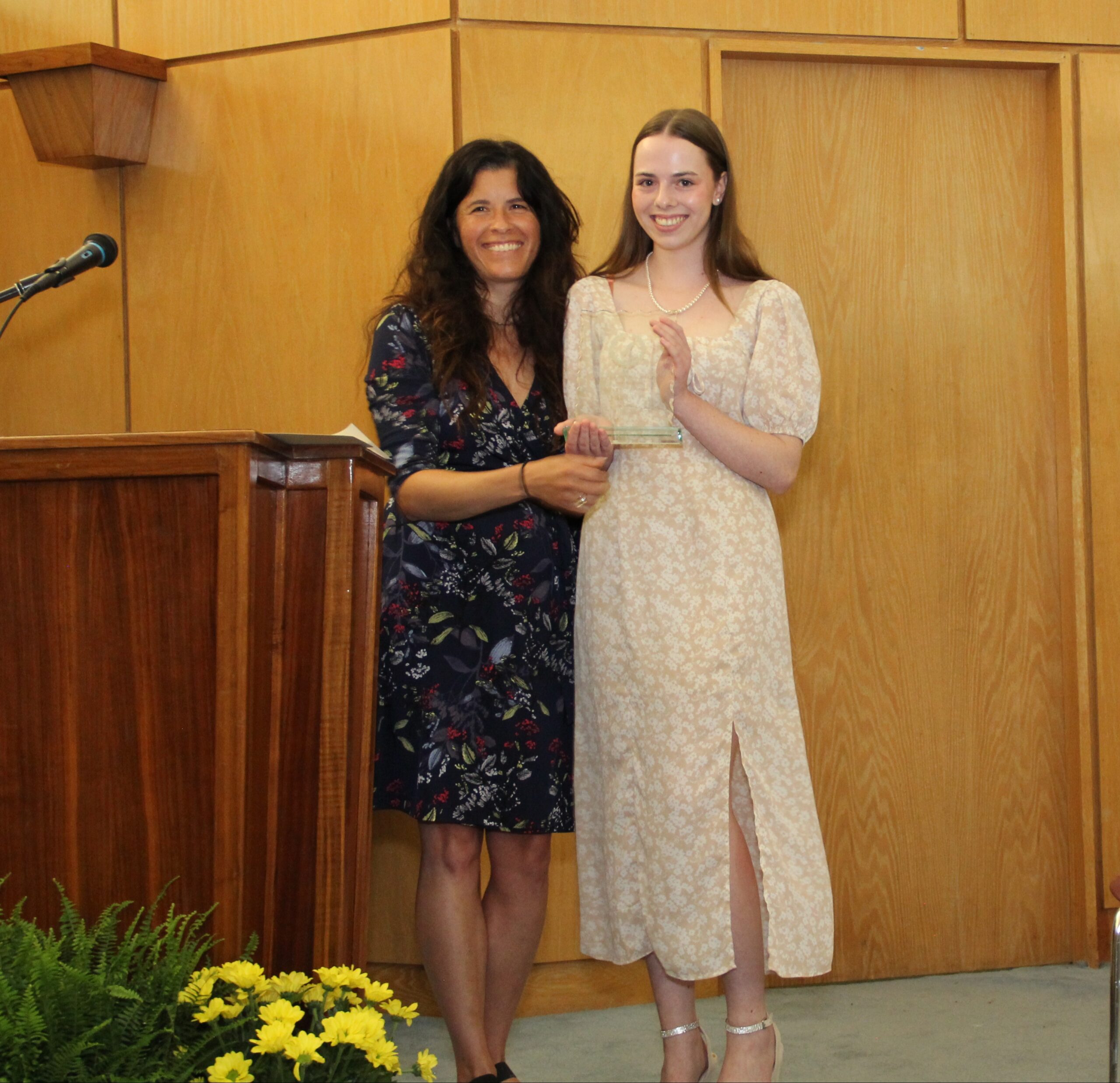 Student and teacher posing with award